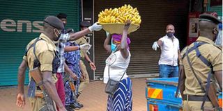 Police officers arrest a vendor in Uganda’s capital Kampala