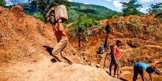 A miner carries ore at Manzou Farm