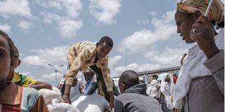 A youngster arranges food aid on a cart