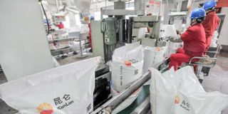 Workers seal sacks of Kunlun urea at a chemical fertiliser plant in China.