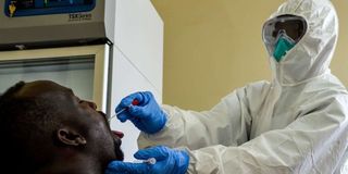 A medical worker collects samples for Covid testing.