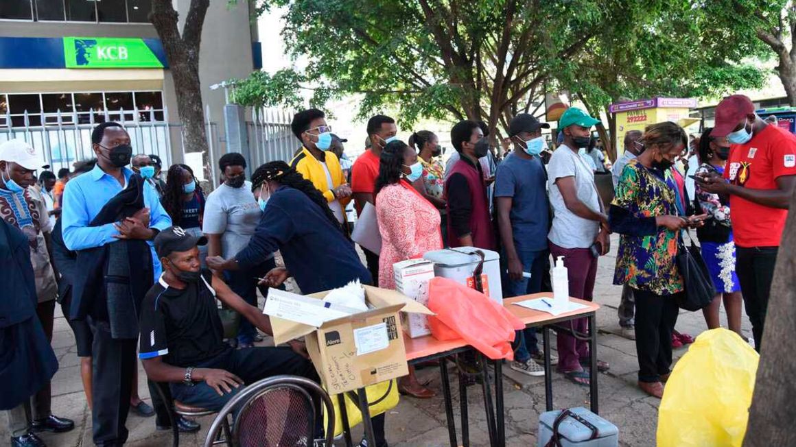 People queue to receive the Covid-19 vaccine at a bus stop in Nairobi, Kenya, on December 29, 2021.