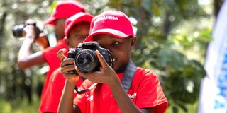 Children practise photography.