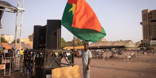 A man holds a Burkina's flag during a gathering to show support to the military