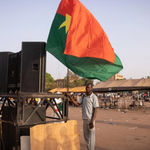 A man holds a Burkina's flag during a gathering to show support to the military