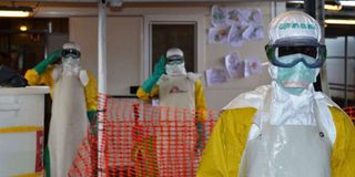 Health workers wearing protective gear at an Ebola treatment centre.