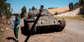 A man walks past a destroyed tank near Debre Tabor