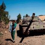 A man walks past a destroyed tank near Debre Tabor