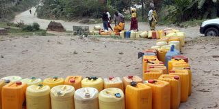 People queue to fetch water. 