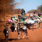 A woman rides a donkey Abyei