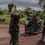 A motorcyclist carries soldiers in Kibumba, DRC