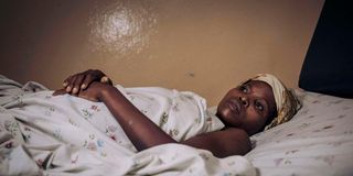 Twizire Bukomeye lies on a hospital bed in DR Congo
