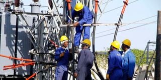 Kenya Power employees repairing a transformer.