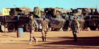 French soldiers walking past their armoured vehicles in Mali 