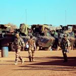 French soldiers walking past their armoured vehicles in Mali 