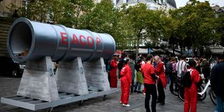 Activists next to a fake Eacop pipeline structure