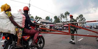 A motorcyclist transporting a potato trader 