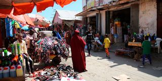 People walk in a street in Mogadishu, Somalia