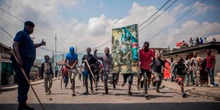 Demonstrators carrying a poster honouring DRC armed forces