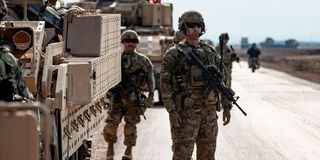 US soldiers stand next to military vehicles