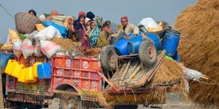 People displaced by floods travel on a tractor in Jaffarabad, Pakistan