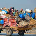 People displaced by floods travel on a tractor in Jaffarabad, Pakistan