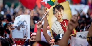 Protesters hold images of detained civilian leader Aung San Suu Kyi 