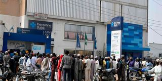 People queue to withdraw money in Kano