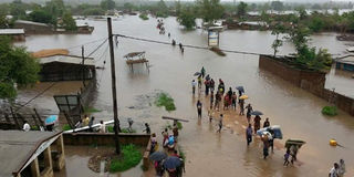 People walk in floods in Mozambique’s Matola region