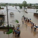 People walk in floods in Mozambique’s Matola region