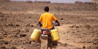 A man ferries water to his home in Kenya’s drought-hit Marsabit