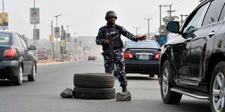 A police officer stops a car at a checkpoint