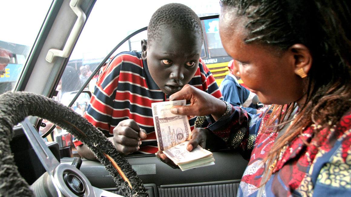 A motorist changes money from a boy in Juba, South Sudan