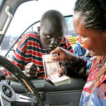 A motorist changes money from a boy in Juba, South Sudan