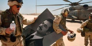 US Marine soldiers carry a portrait of Saddam Hussein