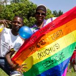 Ugandan men hold a rainbow flag 