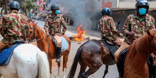 Police on horseback patrol a street in Nairobi