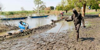 An IDP walks in mud in Tong village, Bentiu 