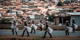 Kenyan anti-riot police officers patrol in Kibera