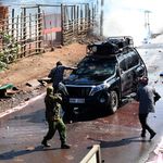 A police officer aims gun at a car that carried journalists