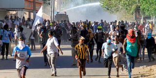 Demonstrators flee from ant-riot police in Sudan.