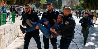 Israeli policemen detain a Palestinian man
