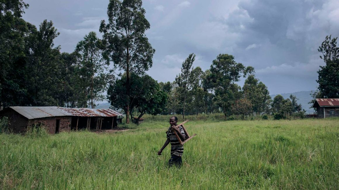 A man moves furniture from a school used by M23 fighters 