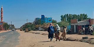 People walk along a deserted street in southern Khartoum