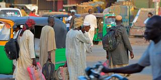 Men walk along a street in Khartoum's twin city of Umdurman 