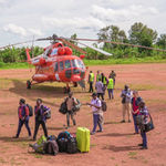 Aid workers and passengers disembark from a UNHAS helicopter