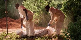 Workers carry a body bag to the mortuary from Shakahola