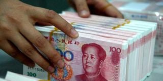 A bank teller counting Chinese 100-yuan notes. 