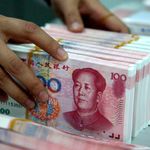 A bank teller counting Chinese 100-yuan notes. 