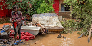 Rwanda floods - A woman salvages household items